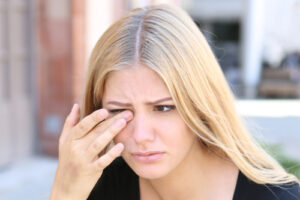 girl itching eye from dry eye 