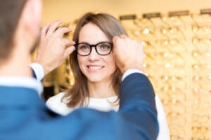 Woman trying on glasses at an optical shop